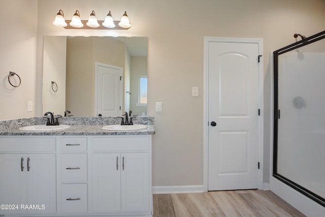 bathroom featuring vanity, an enclosed shower, and wood-type flooring