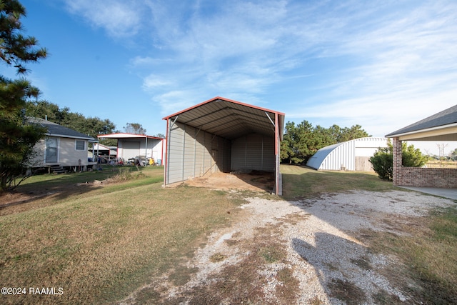 view of outbuilding featuring a lawn and a carport