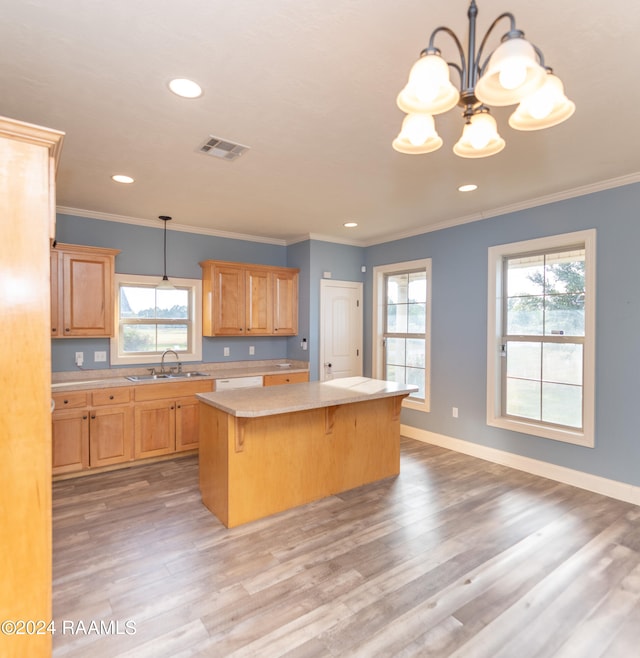 kitchen featuring a kitchen island, a kitchen bar, decorative light fixtures, and light hardwood / wood-style floors