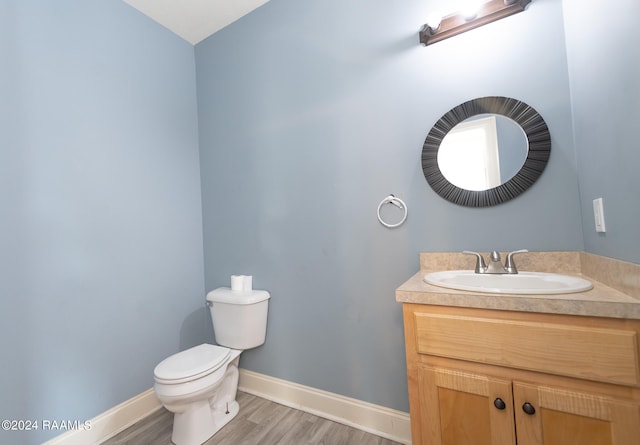 bathroom with vanity, hardwood / wood-style flooring, and toilet