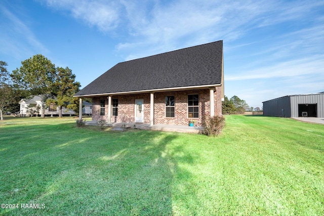 rear view of property with an outbuilding and a yard