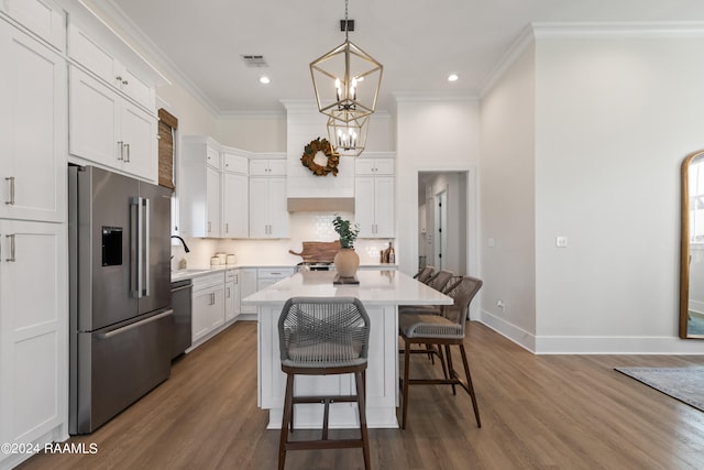 kitchen featuring stainless steel appliances, wood-type flooring, pendant lighting, and white cabinets