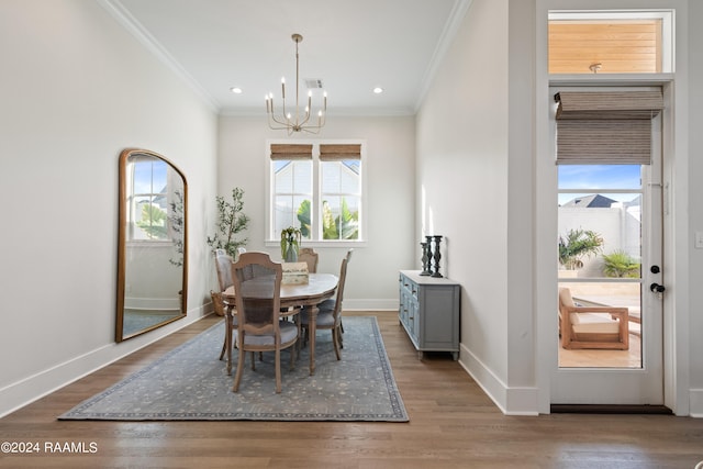 dining room featuring ornamental molding, wood-type flooring, and an inviting chandelier