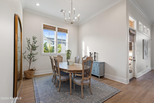 dining space with ornamental molding, a notable chandelier, and hardwood / wood-style flooring