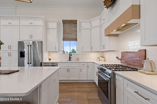 kitchen featuring premium appliances, sink, and white cabinets