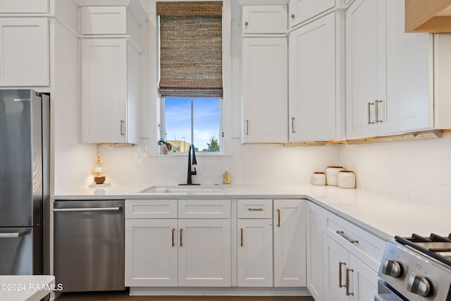 kitchen with sink, white cabinets, stainless steel appliances, and tasteful backsplash