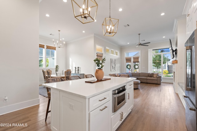 kitchen with hanging light fixtures, a center island, a kitchen bar, and white cabinets