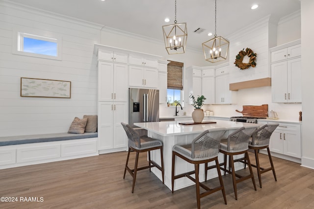 kitchen featuring high quality fridge, white cabinets, and a healthy amount of sunlight