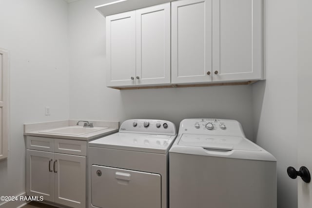 washroom featuring cabinets, sink, and washer and clothes dryer