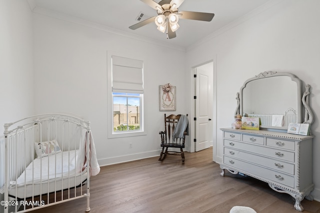 bedroom featuring crown molding, hardwood / wood-style flooring, and ceiling fan