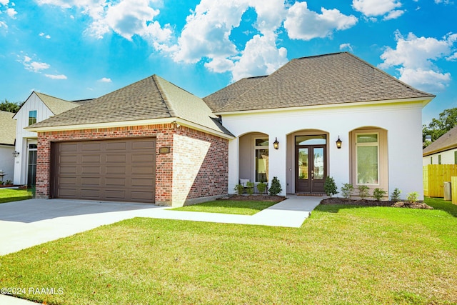 204 Treescape Dr, Lafayette, LA 70508 - french country home with a shingled roof, brick siding, a garage, concrete driveway, and french doors