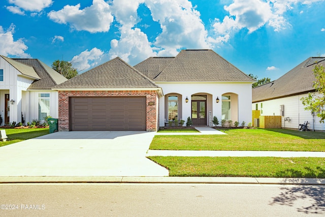 view of front of home with a front yard, a garage, and a porch