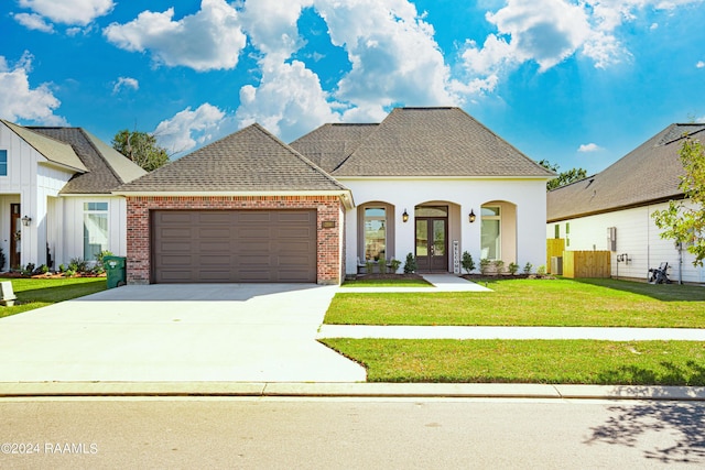 204 Treescape Dr, Lafayette, LA 70508 - french provincial home with driveway, french doors, a front yard, a garage, and brick siding