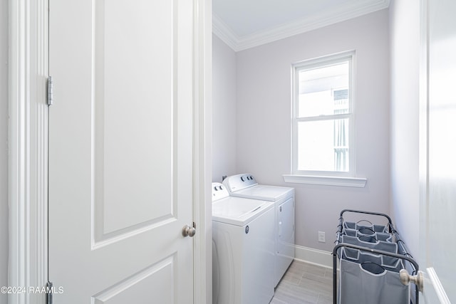 clothes washing area with ornamental molding and washing machine and dryer