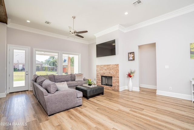 living room with light hardwood / wood-style floors, ornamental molding, and ceiling fan