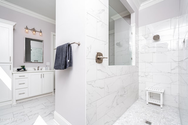 bathroom with a tile shower, ornamental molding, and vanity