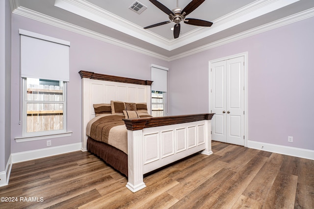 bedroom with dark hardwood / wood-style flooring, multiple windows, ornamental molding, and ceiling fan