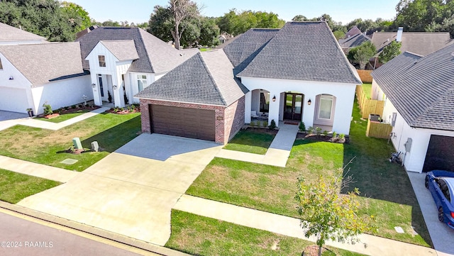 204 Treescape Dr, Lafayette, LA 70508 - french country home with brick siding, a front lawn, concrete driveway, an attached garage, and a shingled roof