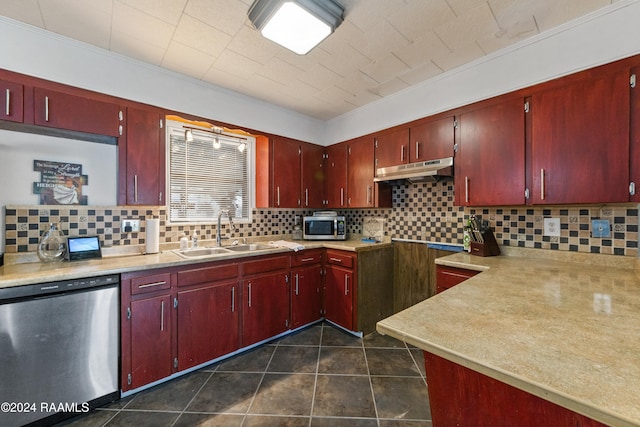 kitchen with dark tile patterned flooring, stainless steel appliances, sink, crown molding, and tasteful backsplash