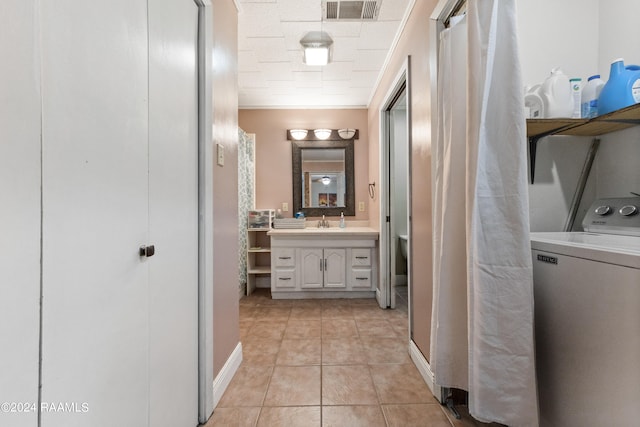 bathroom featuring vanity, crown molding, tile patterned floors, and washer / clothes dryer