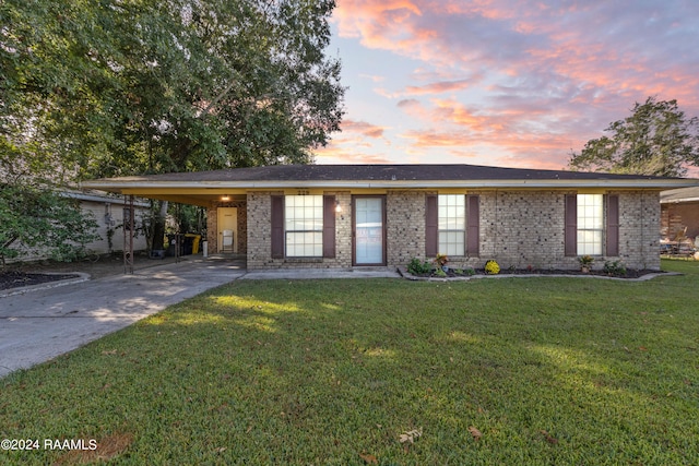 view of front facade featuring a lawn and a carport