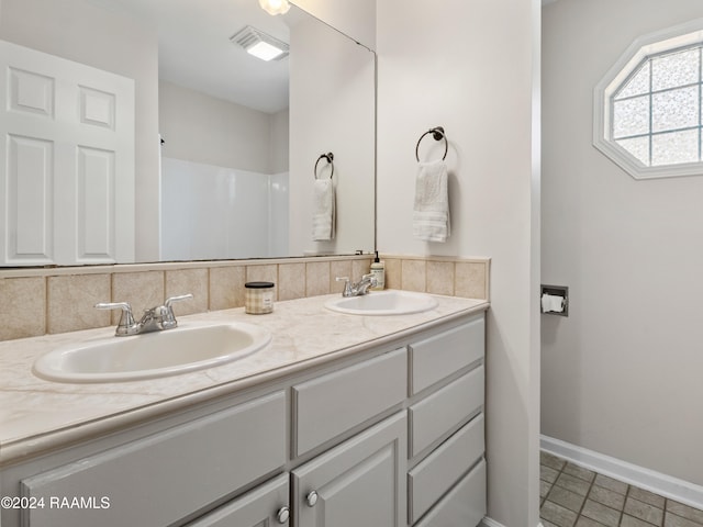 bathroom featuring vanity and backsplash