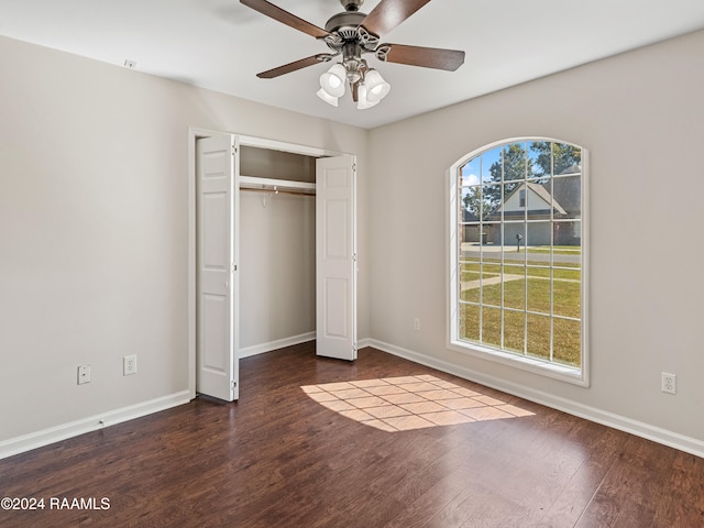 unfurnished bedroom featuring hardwood / wood-style floors, a closet, and ceiling fan