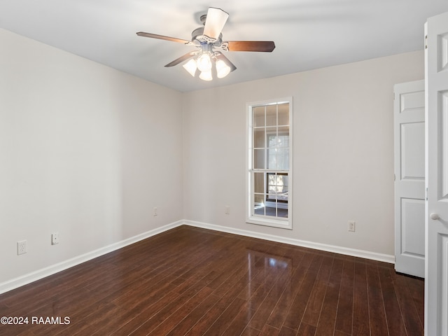 empty room with ceiling fan and dark hardwood / wood-style flooring