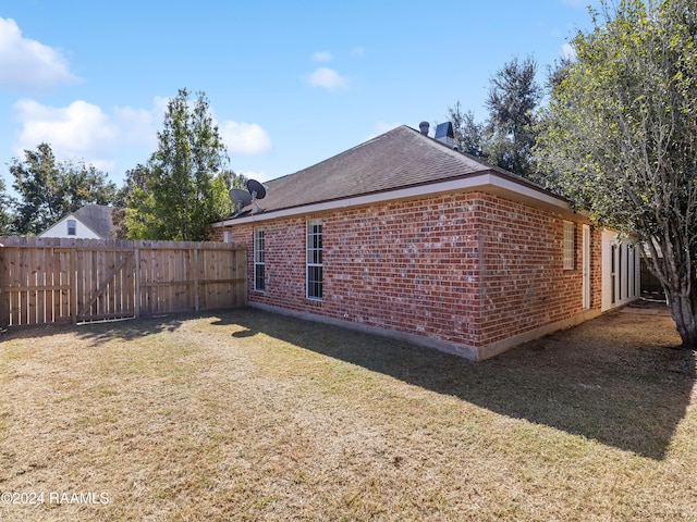 view of side of home with a yard