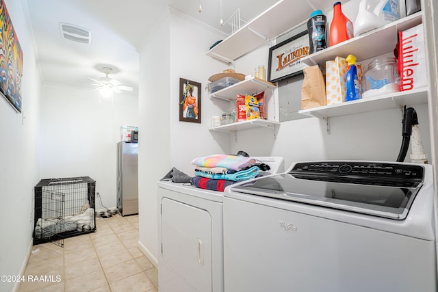 clothes washing area featuring crown molding, light tile patterned floors, washing machine and clothes dryer, and ceiling fan