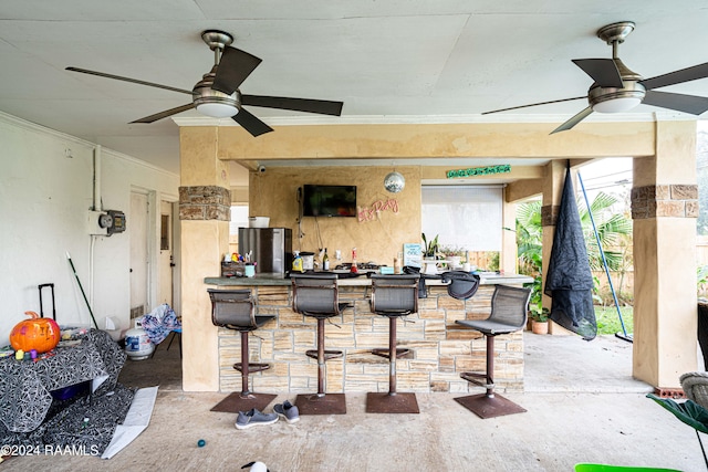 view of patio featuring ceiling fan and exterior bar