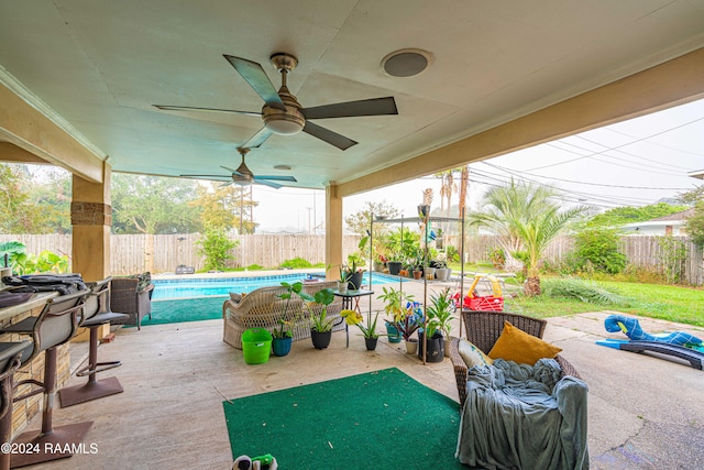 view of patio featuring a fenced in pool and ceiling fan