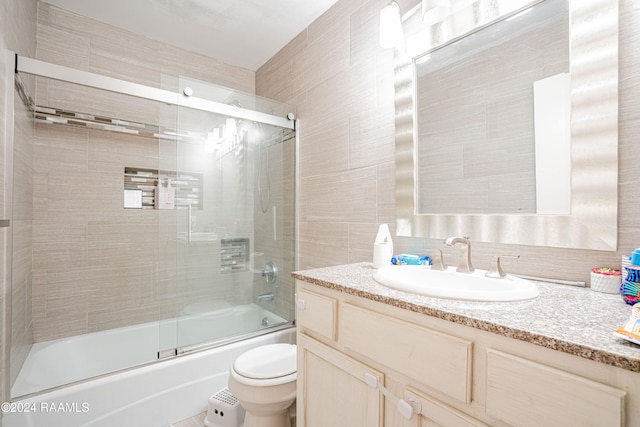 full bathroom with decorative backsplash, toilet, vanity, tile walls, and enclosed tub / shower combo