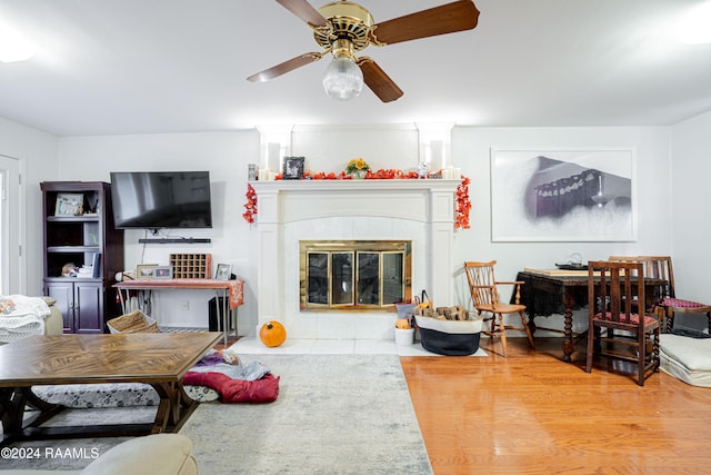 living room with ceiling fan, light wood-type flooring, and a fireplace