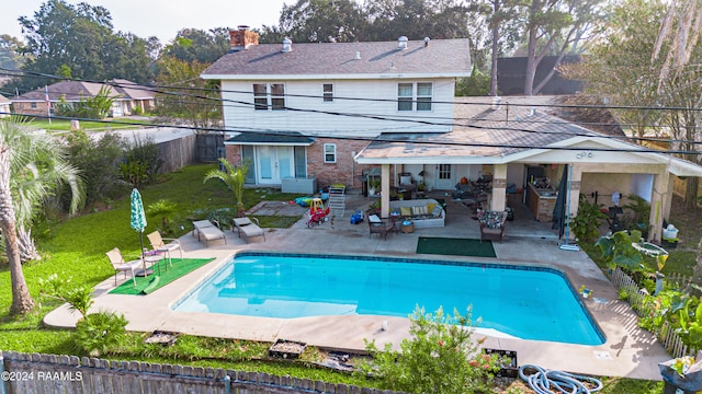 back of house featuring a yard, a patio area, and a fenced in pool