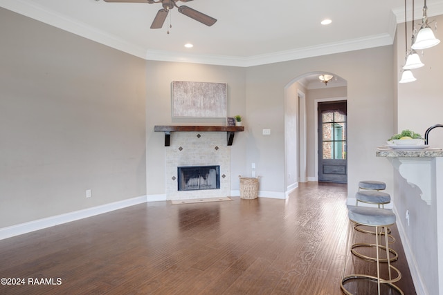 living room with hardwood / wood-style flooring, crown molding, and ceiling fan