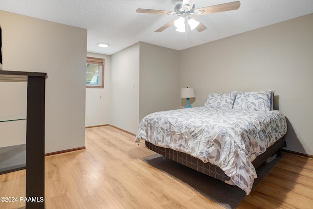 bedroom with baseboards, ceiling fan, and wood finished floors