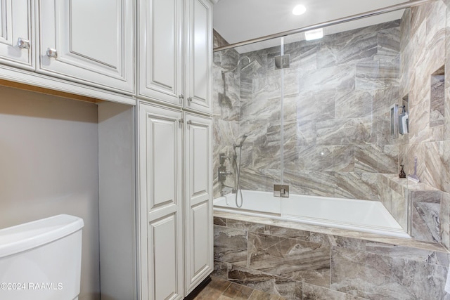 bathroom with recessed lighting, tiled shower / bath, and toilet