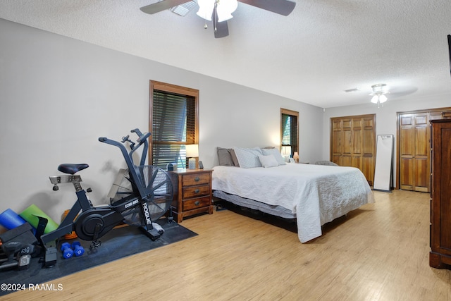 bedroom featuring light wood-style floors, a textured ceiling, and ceiling fan