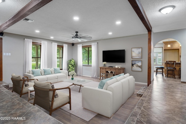 415 Kyle Landry Rd, New Iberia, LA 70563 - living room featuring arched walkways, beam ceiling, a textured ceiling, ceiling fan, and recessed lighting