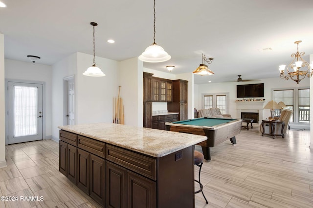 kitchen featuring a center island, light hardwood / wood-style floors, pendant lighting, billiards, and a breakfast bar