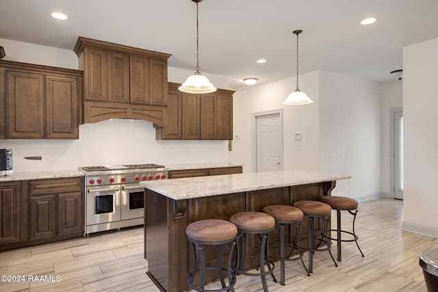 1053 Bayouside Ln, Parks, LA 70582 - kitchen with wood finish floors, a kitchen breakfast bar, a center island, stainless steel appliances, and backsplash
