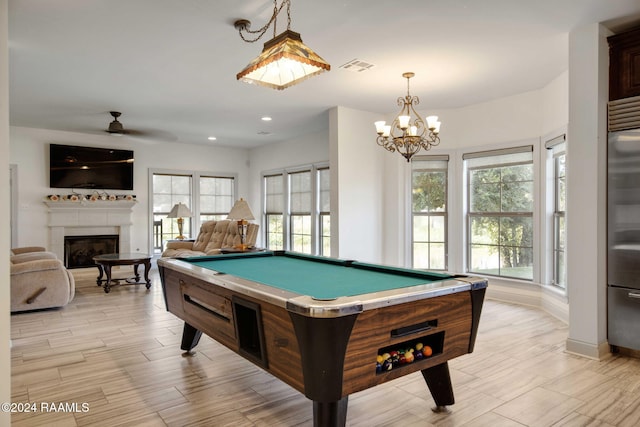 playroom with pool table, light hardwood / wood-style flooring, a healthy amount of sunlight, and ceiling fan with notable chandelier