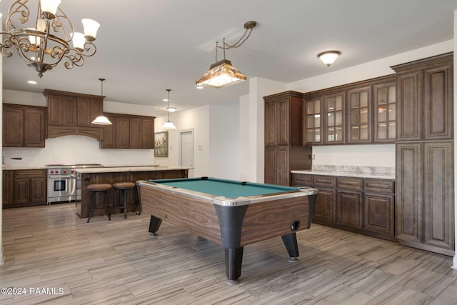 game room with light hardwood / wood-style floors, a chandelier, and pool table