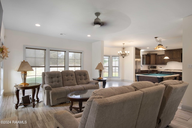 living room with pool table, ceiling fan with notable chandelier, and light wood-type flooring