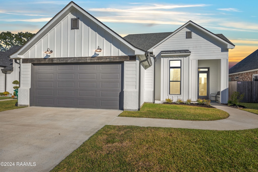 modern inspired farmhouse featuring a yard and a garage