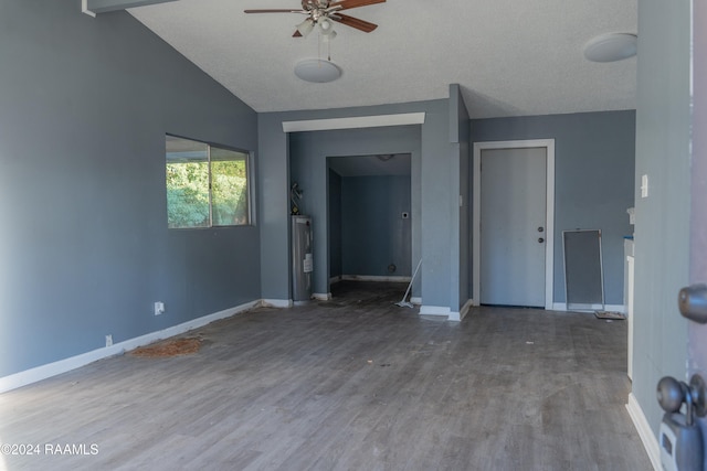 spare room featuring ceiling fan, a textured ceiling, wood-type flooring, vaulted ceiling, and water heater