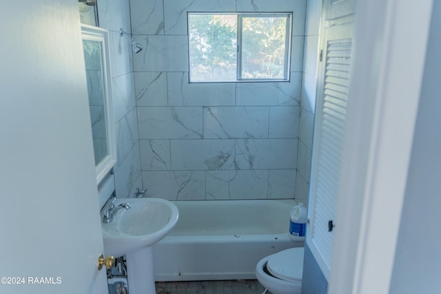 bathroom featuring toilet and tiled shower / bath combo