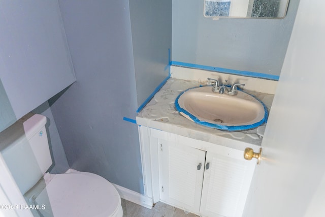 bathroom featuring vanity, hardwood / wood-style floors, and toilet