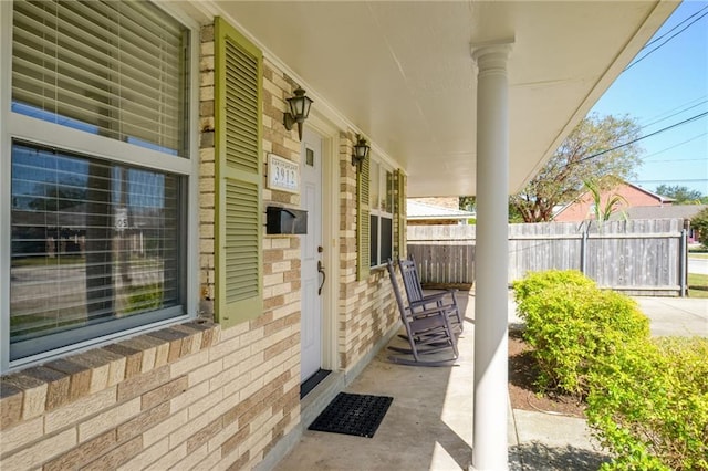 view of patio featuring covered porch and fence